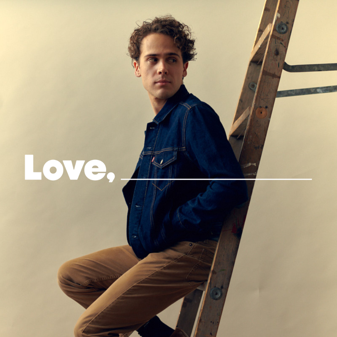 A man sits on a ladder and smiles at the camera